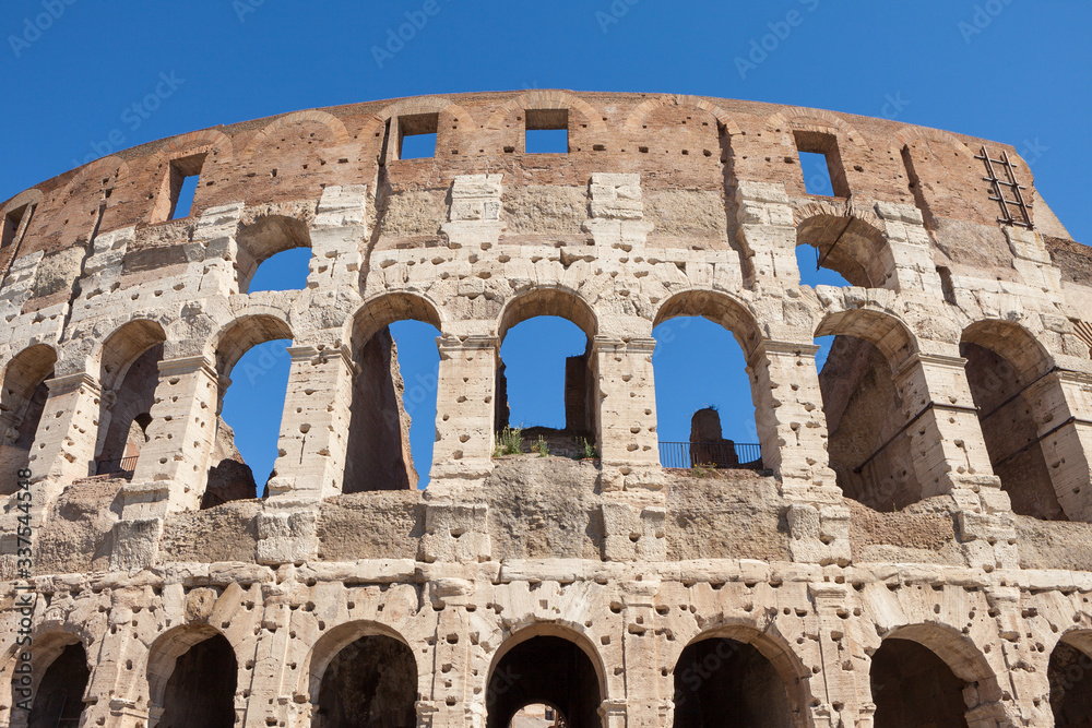 Fragment of arches of Colosseum or Coliseum (Flavian Amphitheatre or Amphitheatrum Flavium or Anfiteatro Flavio or Colosseo. Oval amphitheatre in the centre of the city of Rome, Italy