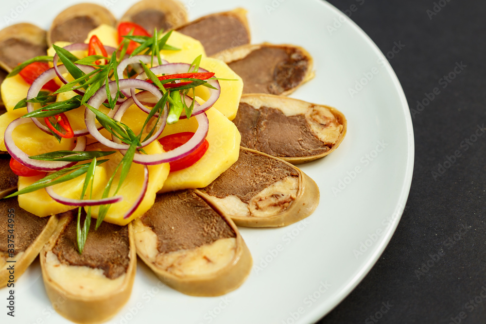 Kazakh cuisine, meat with boiled potatoes onions and herbs, on a white plate