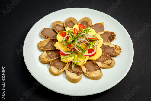 Kazakh cuisine, meat with boiled potatoes onions and herbs, on a white plate photo