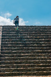 Full shot of a woman climbing stairs on blue sky