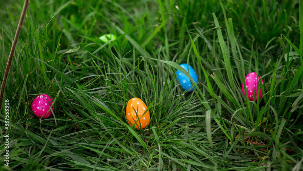 Multi colored Easter eggs scattered around in the grass