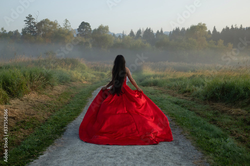 woman in red dress walking on the road lonely thinking of the future
