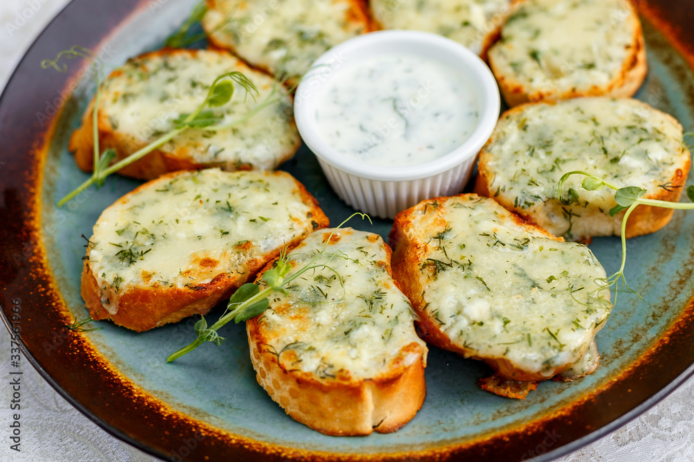 garlic bread with raw greens and sauce on a decorated table garlic bread with raw greens and sauce on a decorated table