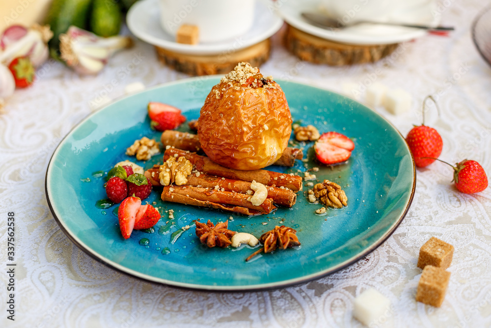 dessert, baked apple with nuts and berries on a decorated table