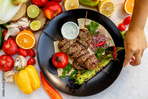 kebab with pita bread and grilled vegetables on a decorated table