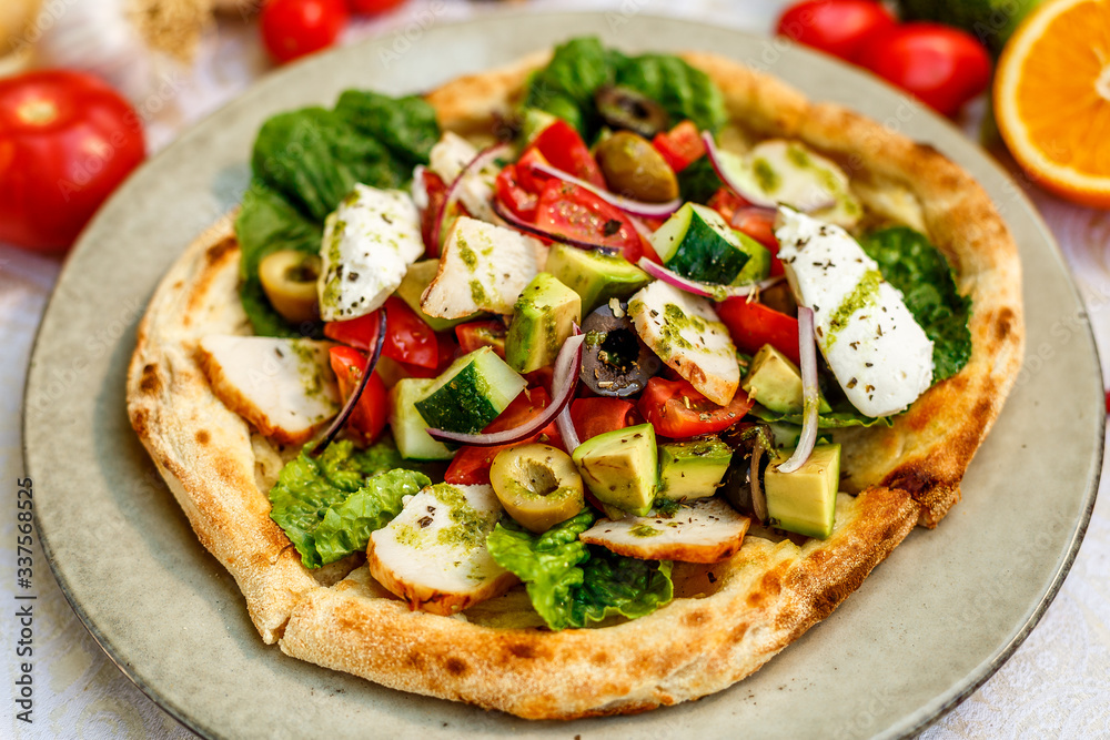 salad with chicken cheese and vegetables on a flat cake on a decorated table salad with chicken cheese and vegetables on a flat cake on a decorated table