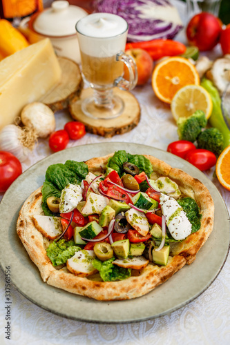 salad with chicken cheese and vegetables on a flat cake on a decorated table