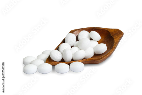 White naphthalene balls in a wooden bowl isolated on a white background.