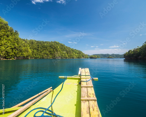 Cruising through the tropical waters of Bucas Grande Island, Surigao del Norte, Philippines on a yellow outrigger boat. photo