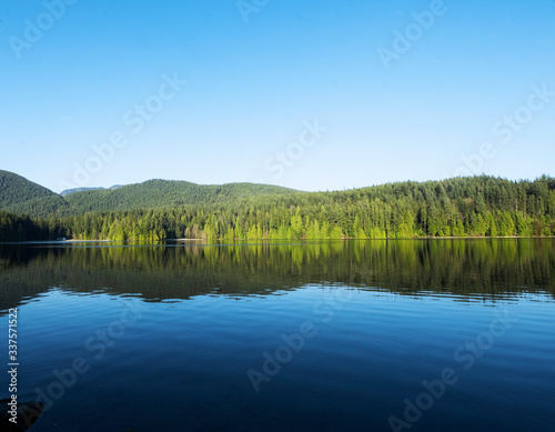 Fototapeta Naklejka Na Ścianę i Meble -  Lake surrounded by rainforest in a sunny day of British Columbia province, Canada.
