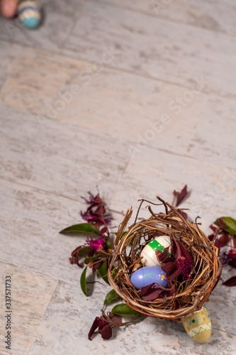 Easter Eggs in a Nest on a Wooden Style Background with Purple and Pink Foliage
