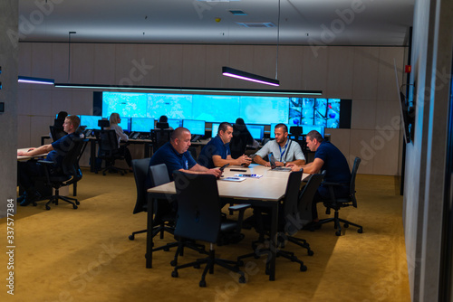 Group (security officers) tech guys meeting in a main security data center office.