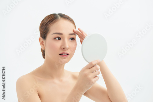 Beautiful Asian woman checking her skin, skin care, acne treatment. Spa and skincare concept.