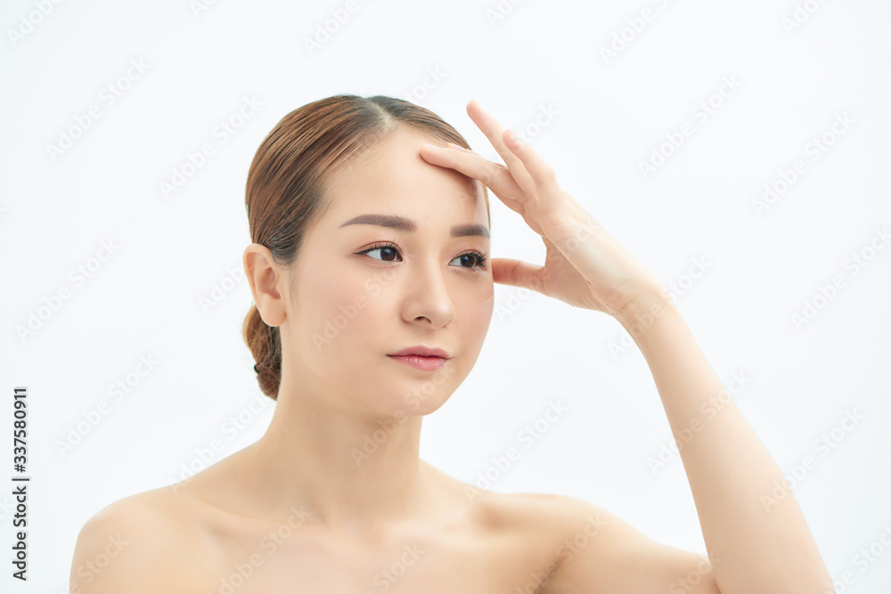 Portrait of beautiful young Asian woman with bare shoulders touching her temples feeling stress, on white background Portrait of beautiful young Asian woman with bare shoulders touching her temples feeling stress, on white background