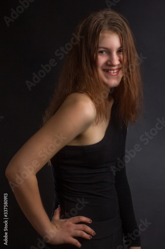 Portrait of girl in a black one-shoulder dress open, naked, in Studio on black background