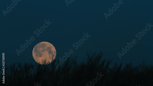 Full moon setting over the horizon in an early morning. Ten second 4k time lapse.