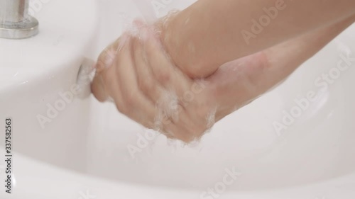 Asian women Cleaning hands with white soap bubbles at Sinks in the bathroom. Hand washing demonstration for virus protection. Concepts of hygiene and prevention of covid 19. Close up of woman hand