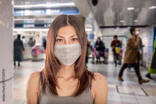 Asian woman wearing surgical mask at Japanese train station