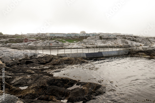 A view to Tananger suburb and rocky coast at Sjobadet Myklebust swimming area early in the morning, Tananger, Norway, May 2018 photo