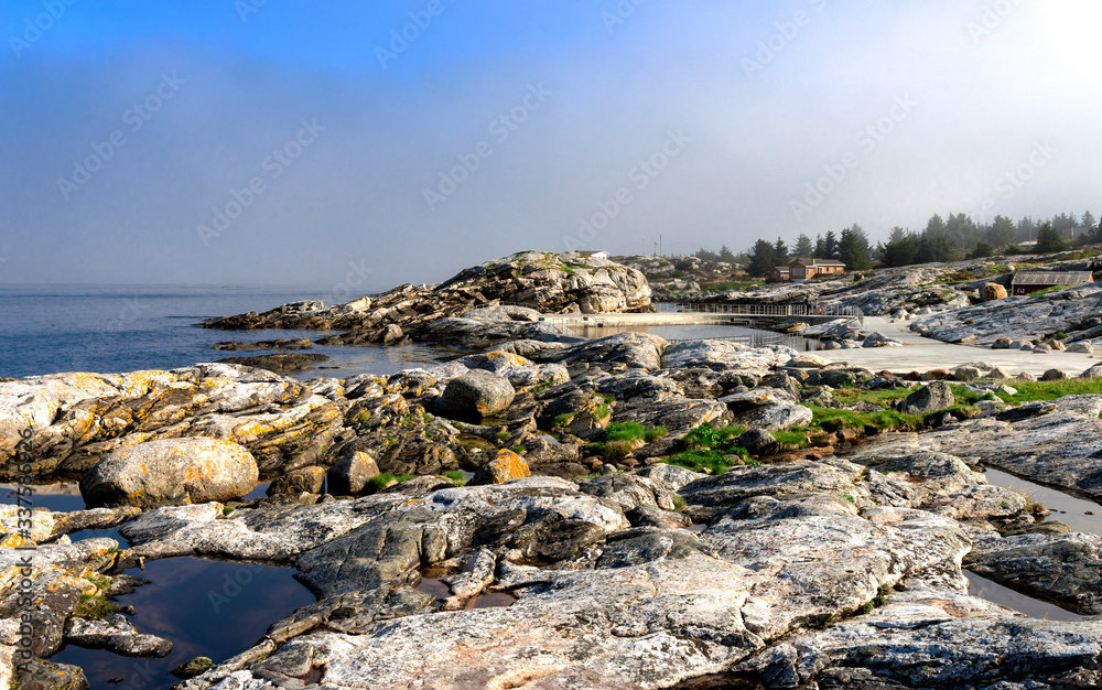 Rocky coast with small water puddles near Sjobadet Myklebust public swimming area, Tananger, Norway, May 2018