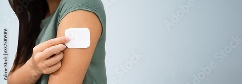 Woman Applying Patch On Her Arm