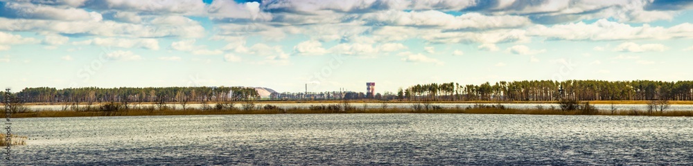 Industry and wildlife. Mining industry. The combination of nature and technology. Ore mining. The extraction of potassium salt. Belarus. Salihorsk. The mine on the background of the river.