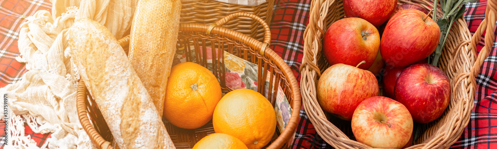 close up picnic basket with fruit and bakery on red cloth in garden. close up picnic basket with fruit and bakery on red cloth in garden.