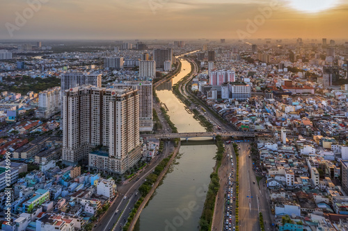 Aerial panoramic cityscape view of HoChiMinh city and the Nhieu Loc canar , Vietnam with blue sky at sunset.  photo