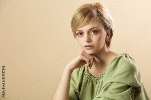 Studio portrait of young woman in green shirt. Studio shot of young beautiful woman. 