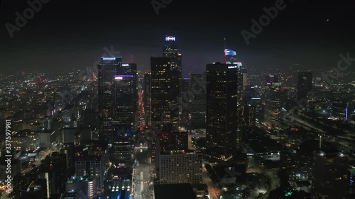 Downtown Los Anges. Aerial view over night cityscape with modern highrises on the front view. The city is beautifully lit with night citylight. Fireworks are seen over the city far on the horizon. 4K photo