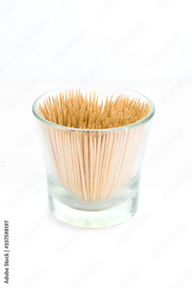 A small glass filled with toothpicks, isolated on white background