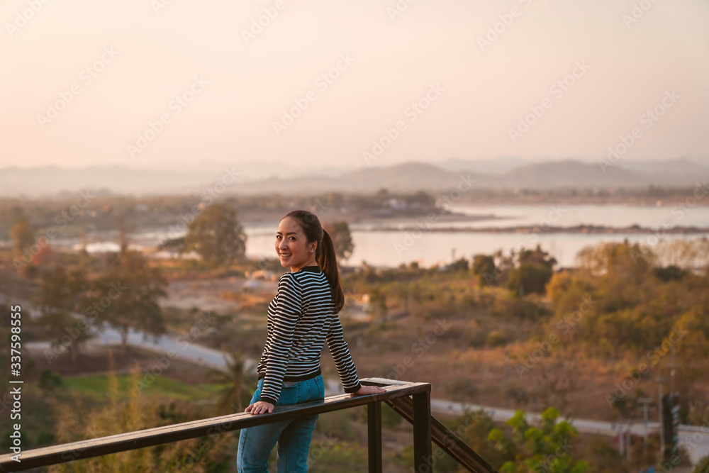 Fototapeta premium hipster girl posing smile relaxing on the mountain in sunset at Northeast at Chiangkhan of Thailand