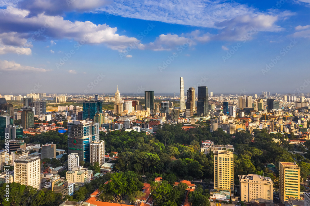 Fototapeta premium Top view aerial photo from flying drone of a Ho Chi Minh City with development buildings, transportation, energy power infrastructure. Financial and business centers in developed Vietnam.