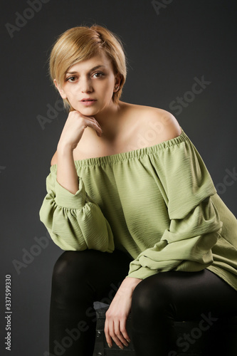 Studio portrait of young woman in green shirt. Studio shot of young beautiful woman. 
