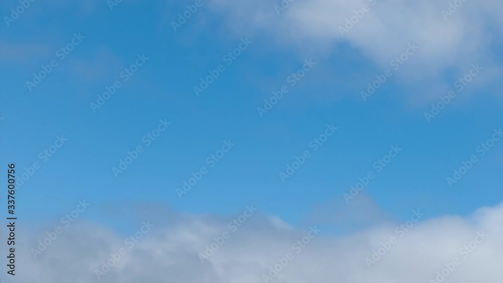 White fluffy clouds moving right to left against blue sky time lapse White fluffy clouds moving right to left against blue sky time lapse