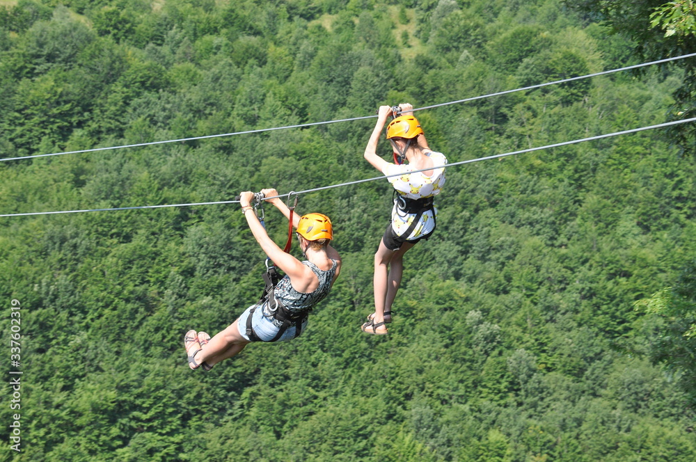 Mother and daughter riding down a zipline over the Tara a river