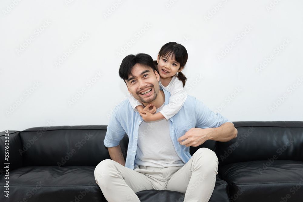 A pair of young Asian father and daughter are playing in the living room