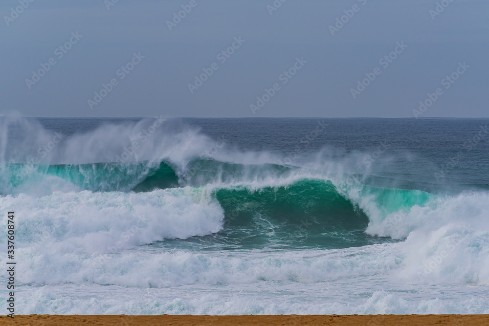 Fototapeta premium Breaking waves along the Nazare Beach,Portugal - Nazare North Beach is a very famous as surfing point due to big wave.
