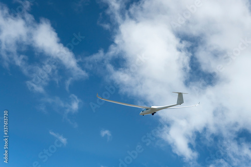 glider climbing under scattered white clouds,  New Zealand