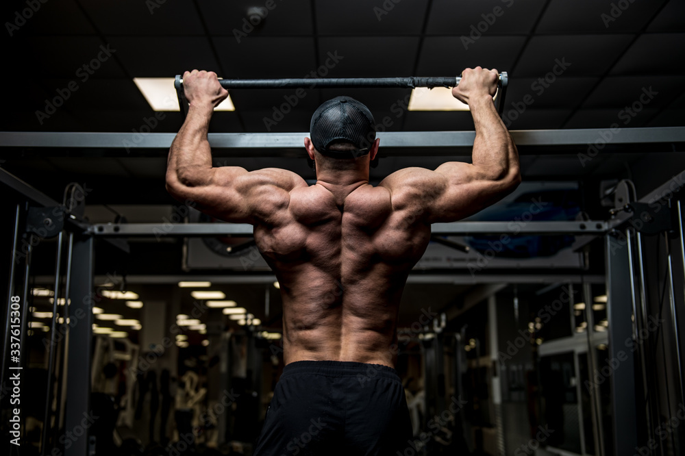 strong young man lifting his heavy weight body during chin ups on horizontal bar in sport gym during workout training strong young man lifting his heavy weight body during chin ups on horizontal bar in sport gym during workout training
