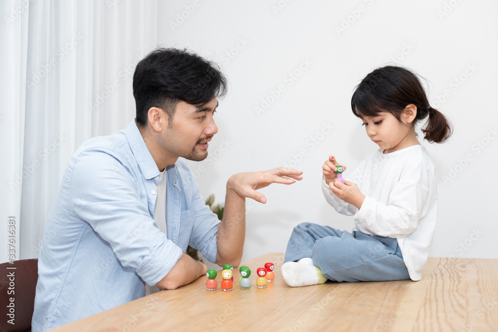 A pair of young Asian father and daughter are applying nail polish in the living room A pair of young Asian father and daughter are applying nail polish in the living room