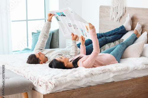 Happy young couple reading ...
