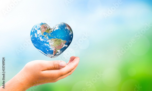 Earth Day concept: hand hold Earth in Heart shape on Natural background, Elements of this image furnished by NASA