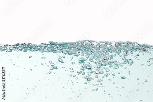 Close up blue water splash with air bubbles on white background isolated. Advertising image with free space for your work