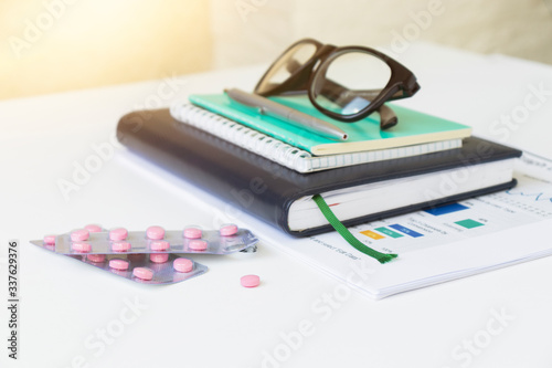 Medical pills pack with glasses and notepad for recipe. Healthcare notes and recommendations.