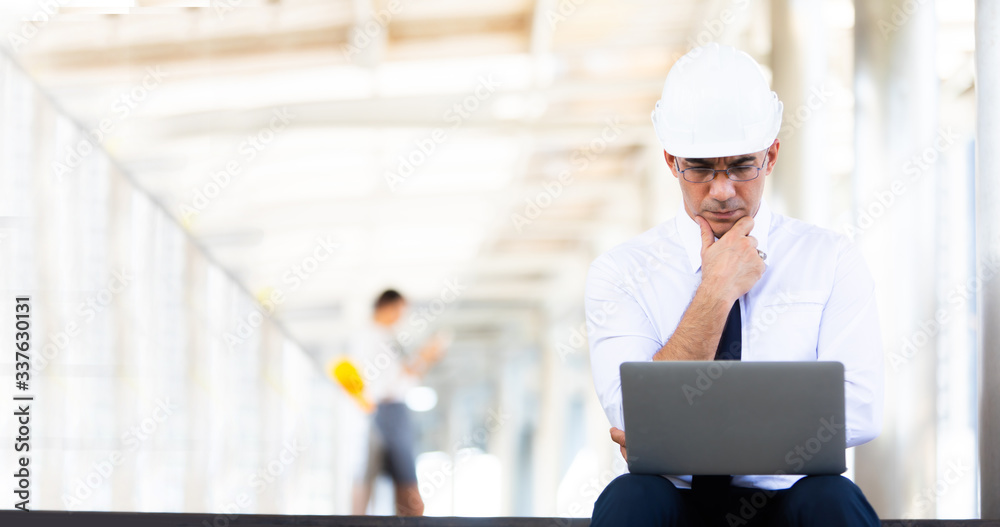 Professional team engineering. Confident architect at construction sit. Portrait Confident architect man working on laptop computer with white safety hardhat at construction site