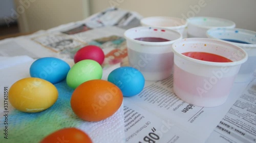 Freshly painted colorful Easter eggs on the table on the newspaper
