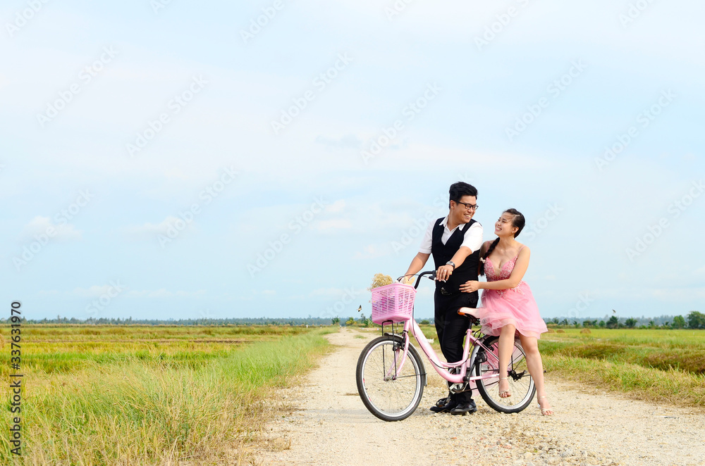 Asian bride and groom on the bicycle