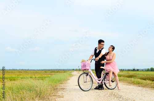 Asian bride and groom on the bicycle
