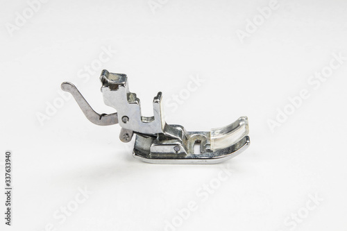 Metal sewing machine foot isolated on a white background.  Close up macro